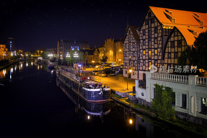 在波兰度假——晚上，比德哥什的布尔达河上有旧驳船和老城建筑