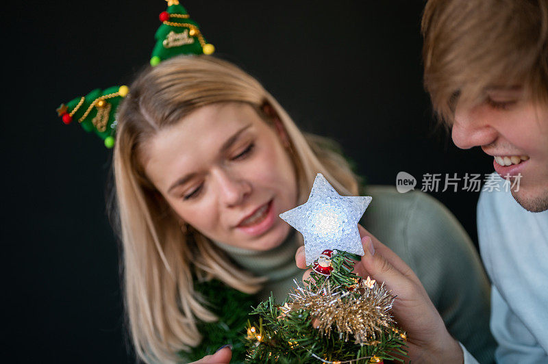 年轻夫妇在家里装饰圣诞树