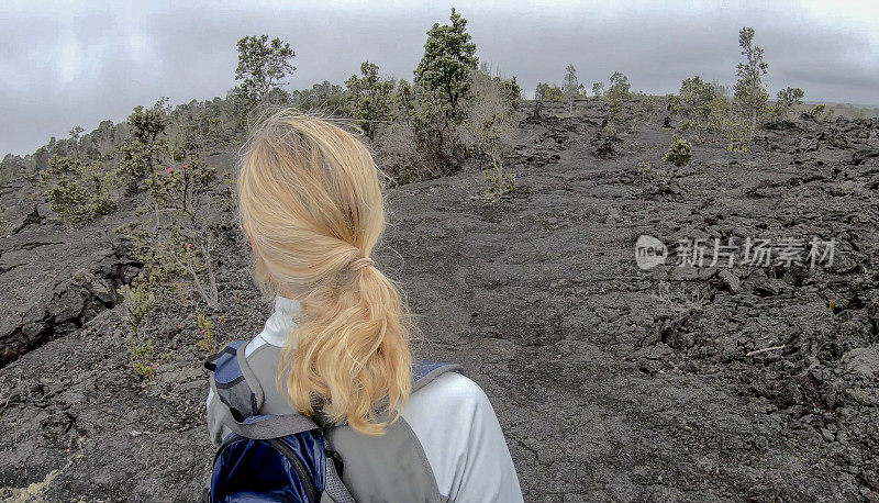 女人沿着火山景观徒步旅行