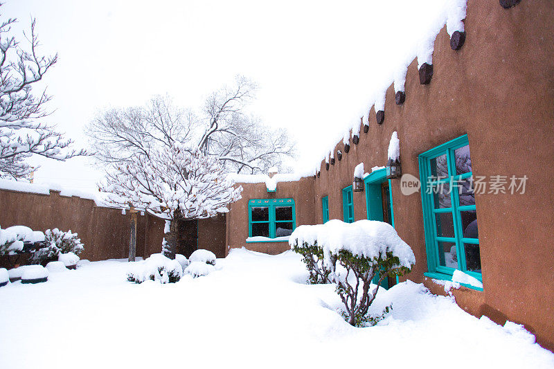 圣塔菲，NM:雪中的传统土砖家庭院