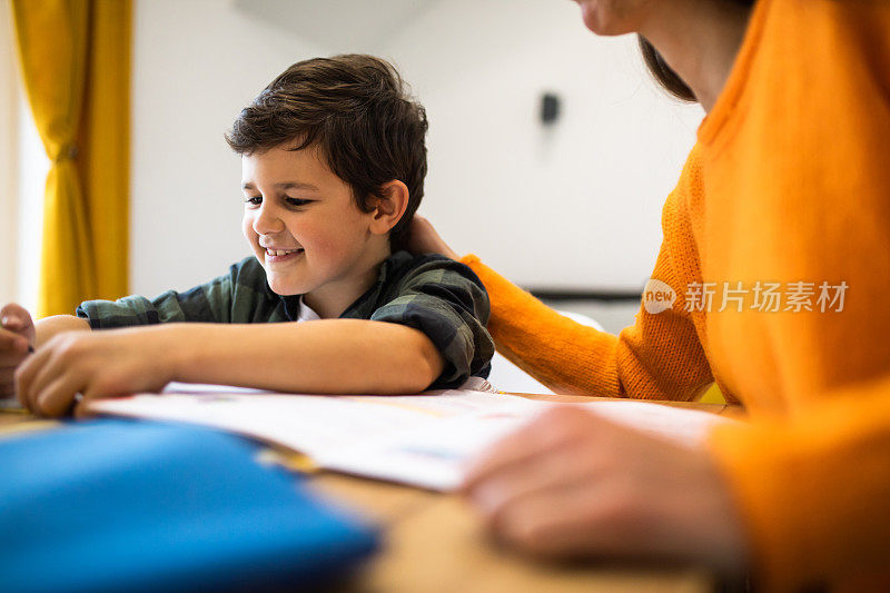 一个快乐的男孩和他妈妈一起做作业