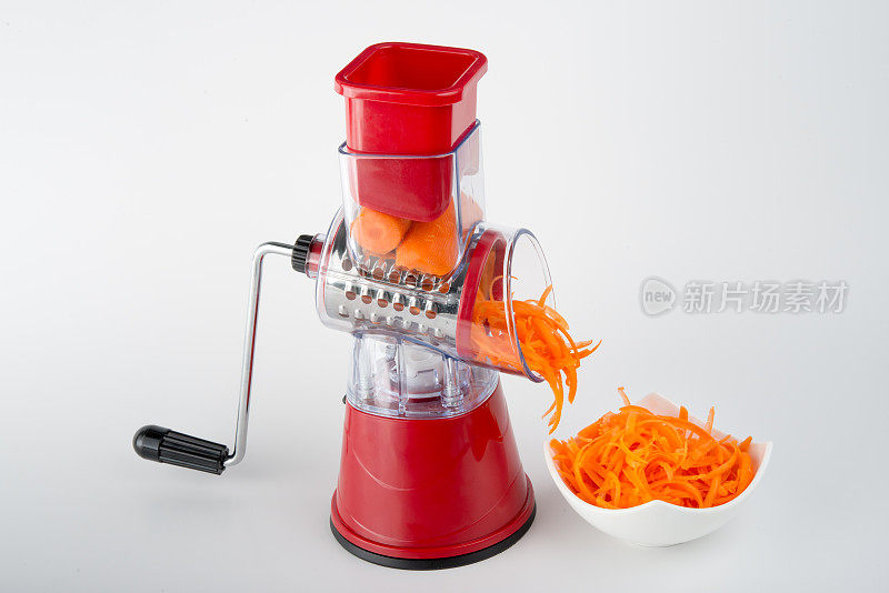 准备蔬菜-切碎的胡萝卜从手动碎纸机出来
