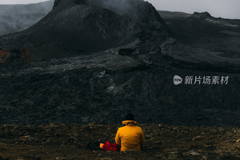 在冰岛的法格达尔斯火山喷发时，游客们感到敬畏