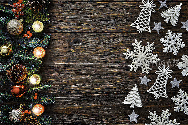 俯视图的圣诞花环，点燃的蜡烛和雪花在质朴的木桌