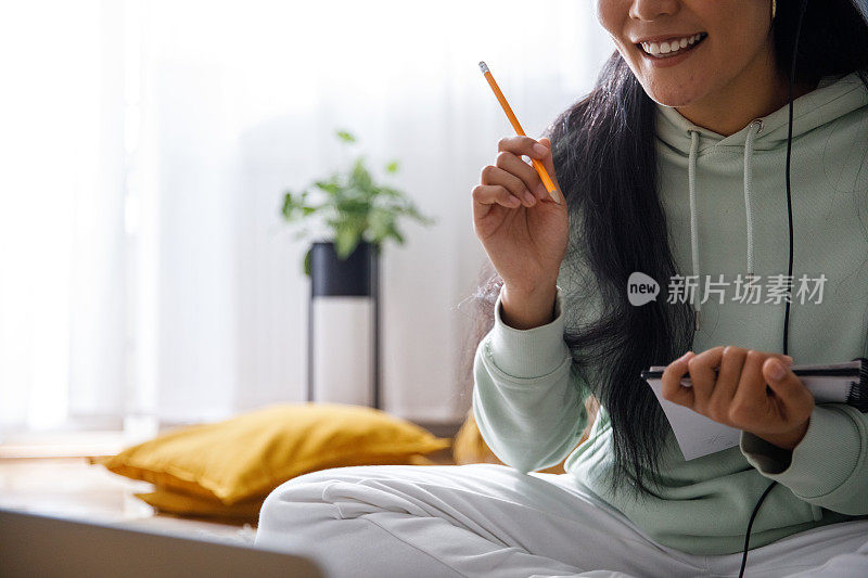 一名年轻女子在网上课堂上写笔记的镜头