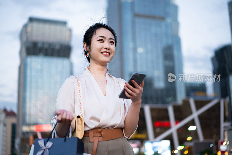 亚洲商业女性站在城市街头，写字楼背景，成功、自信的女性理念