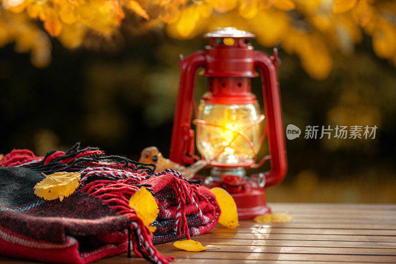 秋天的成分。暖暖的羊毛红毯，灯笼，装饰品，木桌上的秋叶。秋天的概念。秋天背景
