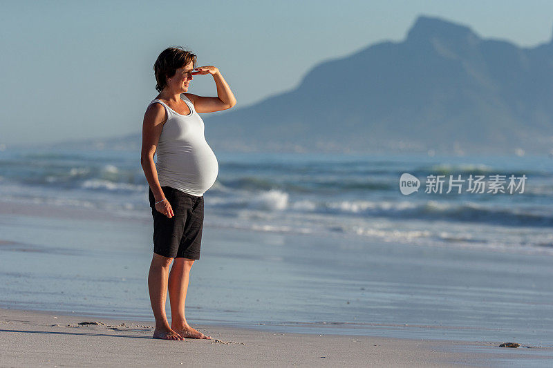 孕妇赤脚站在沙滩上看风景