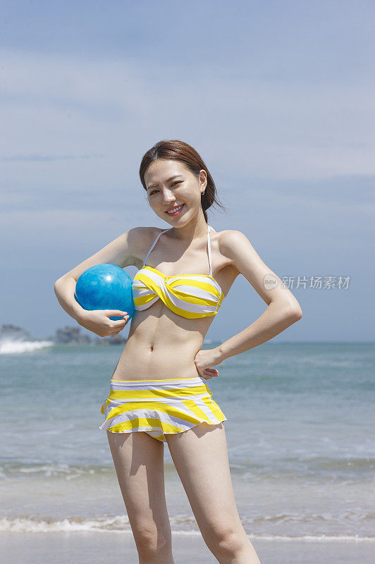 年轻女人拿着海滩球