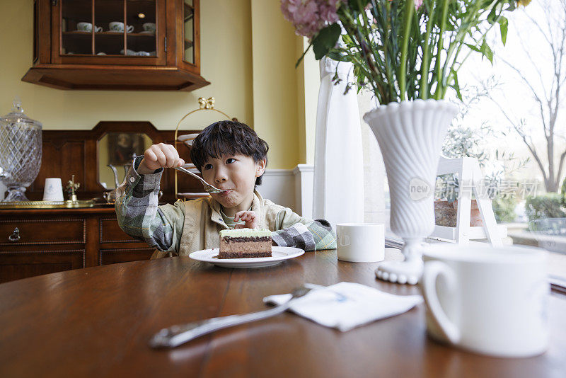 一个小男孩在厨房里吃蛋糕