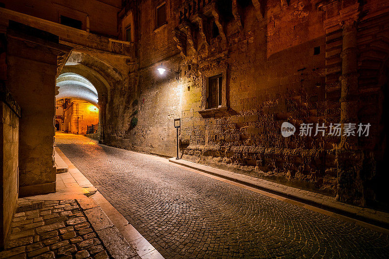 意大利南部的马泰拉老城，一条石头小巷的田园夜景