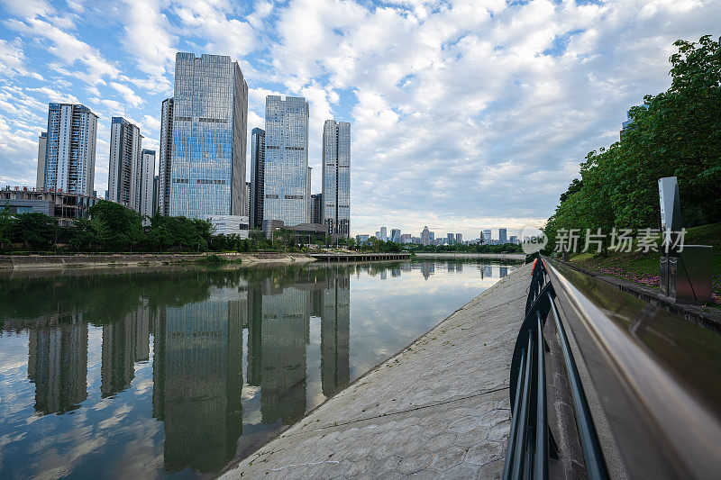 阳光明媚的日子里，沿河有现代化的建筑和桥梁