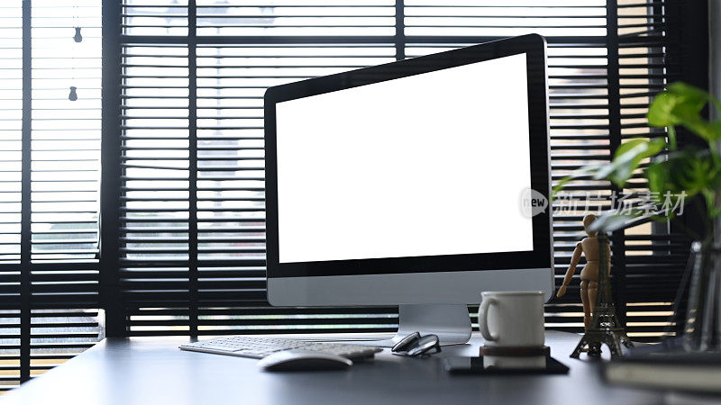 家庭办公桌，电脑，咖啡杯，pacs和室内植物。空屏幕为您的广告文本。