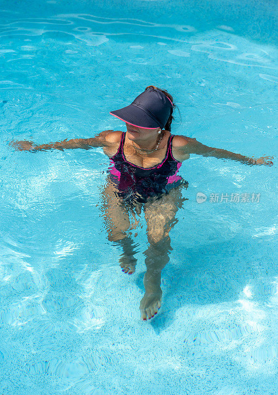 迷人的年长西班牙裔女子在游泳池