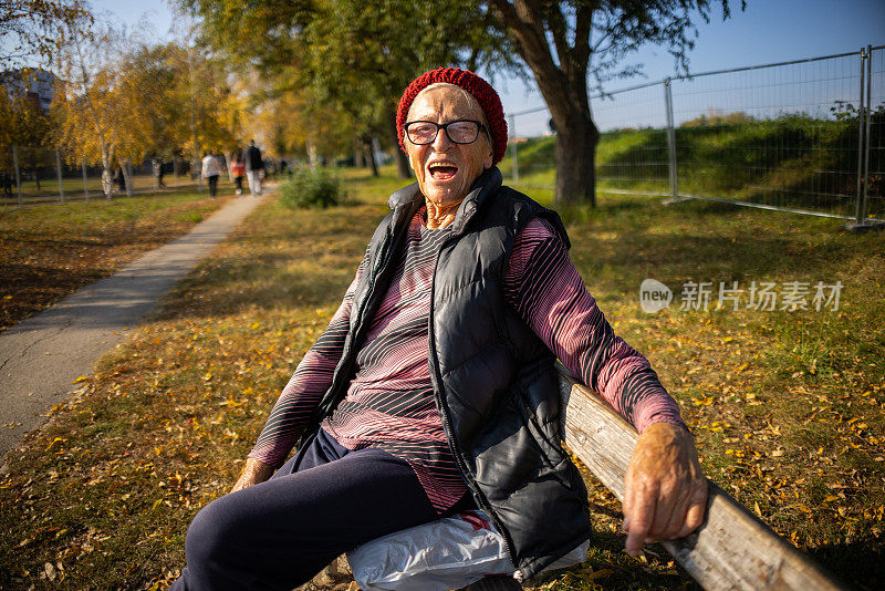 白种老年妇女在公园里享受美丽的秋日