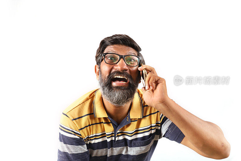 一个穿着黄色衬衫的印度大胡子男子的肖像，展示他的智能手机。