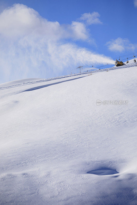 用造雪枪造雪。滑雪坡人工下雪。滑雪场配雪炮造雪机。美丽的冬季自然。山顶上的新雪。高山景观滑雪场。