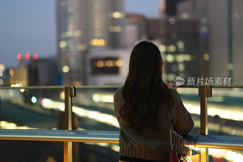 美丽的年轻女子享受夜晚的城市风景