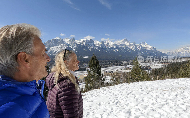 成熟的夫妇走在雪山小路上