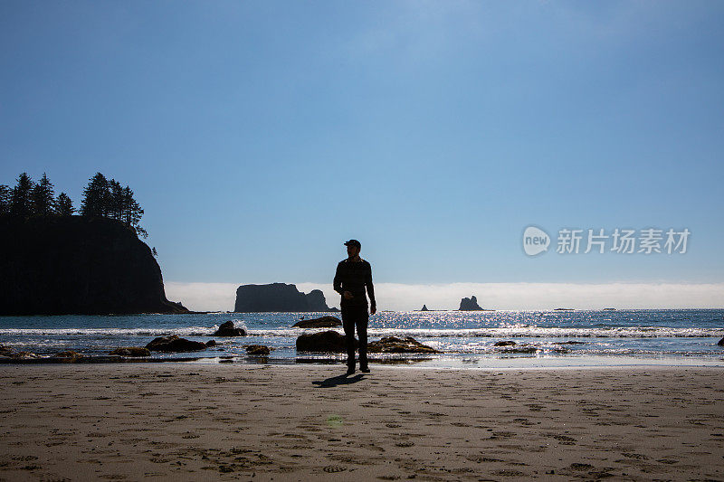 男人站在太平洋西北海滩白天，奥林匹克国家森林国家公园拉普什海滩太阳在天空福克斯华盛顿太平洋