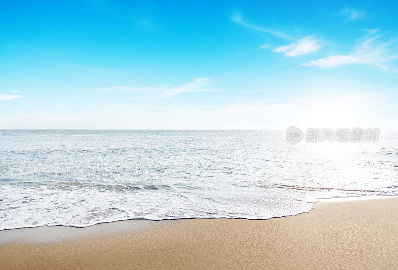 空旷的海滩和大海，背景是晴朗的天空