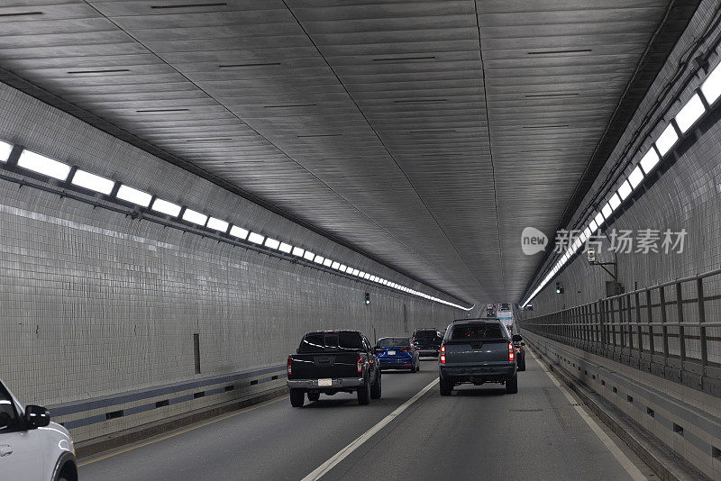 地下开车。汽车行驶在昏暗的汉普顿路大桥隧道在弗吉尼亚州。驾驶牌照，POV汽车司机