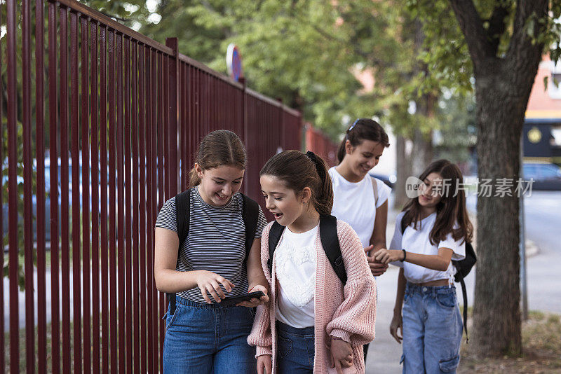 女学生走路上学时使用智能手机