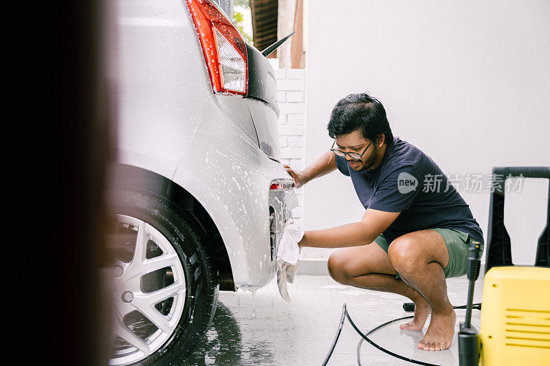 年轻人用肥皂洗车，洗车