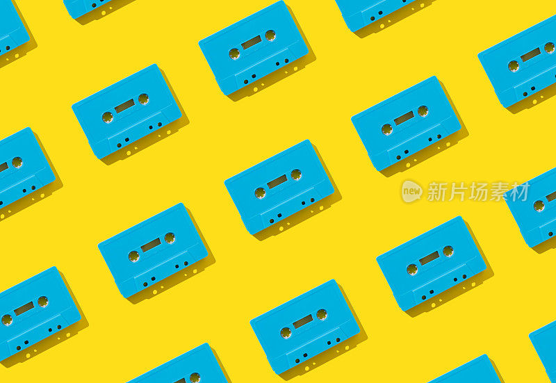 图案与黄色背景上的复古蓝色录音带。复古科技的创意理念。80的审美。老式音频盒式磁带模式的想法。复古的怀旧。平的。