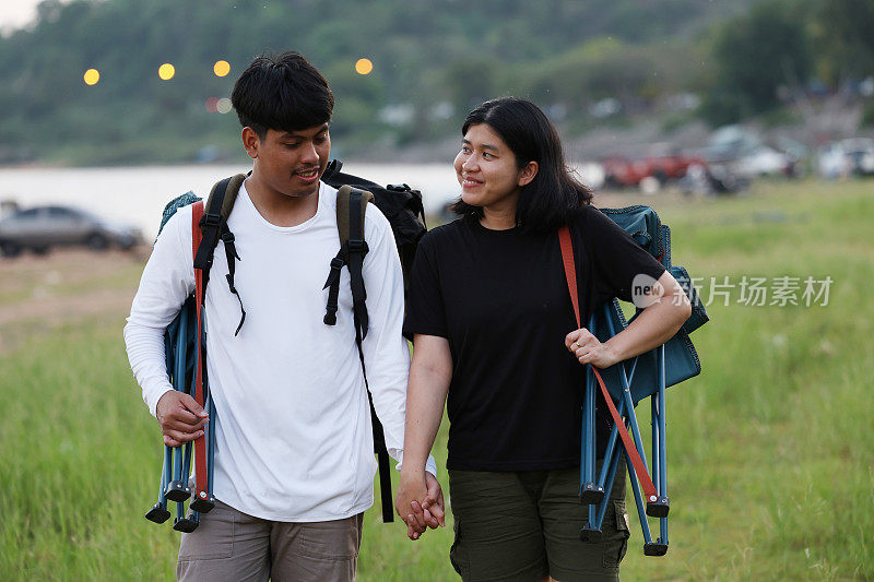 一对徒步旅行者在森林小径上。男男女女徒步旅行者在山上徒步旅行。一对年轻夫妇背着背包在森林里散步。