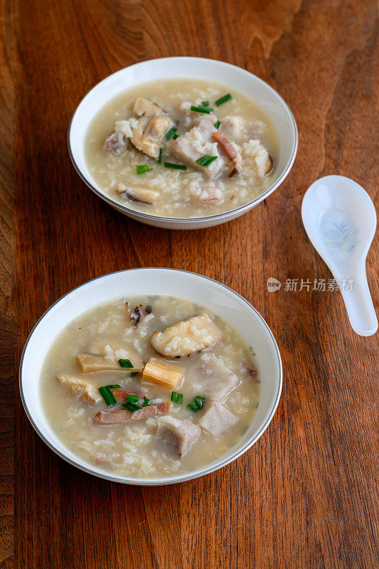 传统的中国食物——美味的海鲜和鸡汤粥，装在古董骨瓷碗里