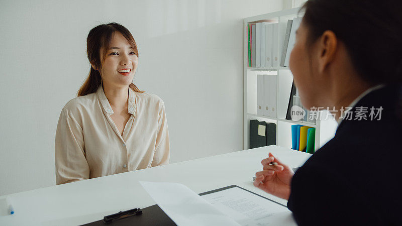 年轻的亚洲女性通过面试，坐在办公室的人力资源经理面前。人力资源，招聘机构。