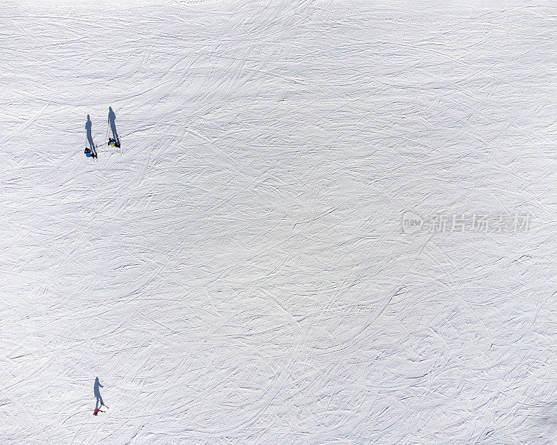 航拍的滑雪者在雪坡上以各种姿势的影子，就像在皮影戏中一样