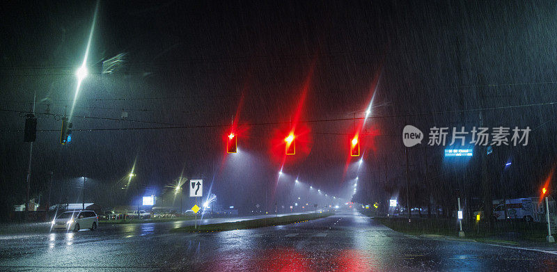 在暴雨中等待红色信号。在佛罗里达州坦帕市的夜间道路上驾驶。驾驶牌照，软焦点