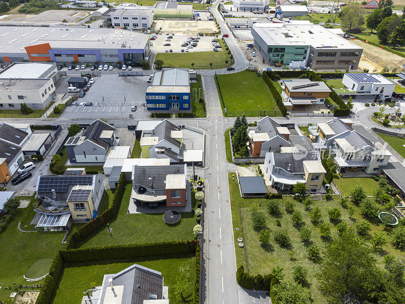 鸟瞰图，一个郊区社区的现代住宅，有太阳能电池板和绿色草坪，展示了城市规划和住宅建筑。