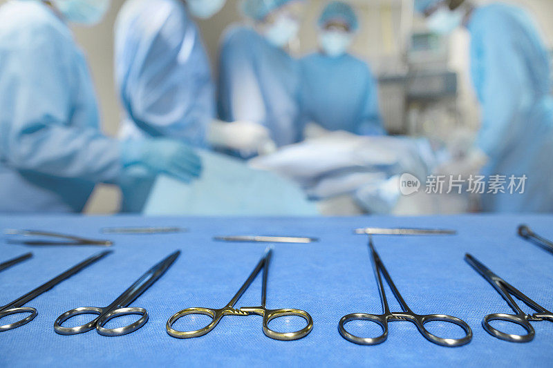 医院外科手术室医疗手术工具托盘近景与医疗专业医师、护理人员