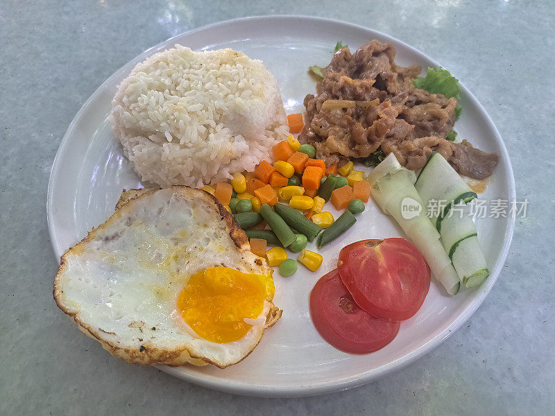 牛肉烤鸡饭配米饭，煎蛋卷蛋，牛肉烧烤，生菜，番茄，黄瓜和混合蔬菜。食品菜单。