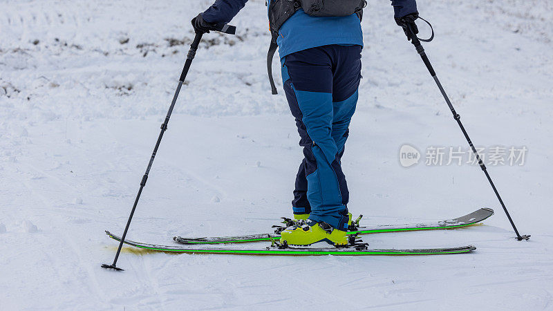 一个人在滑雪或登山时进行180度转弯的步法细节。一个人在滑雪板上转弯向山上走。步骤2