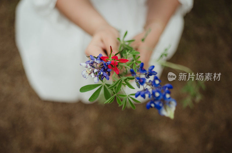 小女孩拿着一束五颜六色的野花