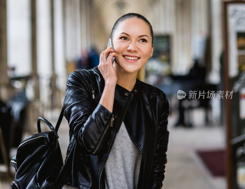 美丽的年轻女子在现实生活中使用智能手机