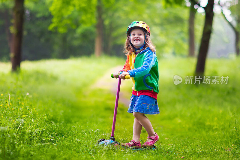 小女孩骑着彩色滑板车