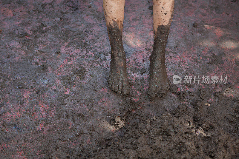 孩子们光着脚在泥泞的地面上