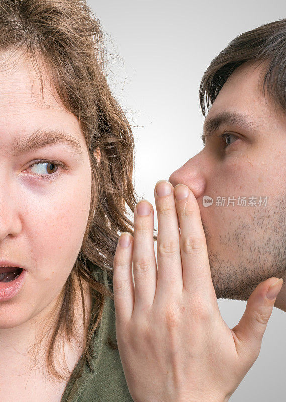 震惊的女人在听八卦。男人对女人耳语。