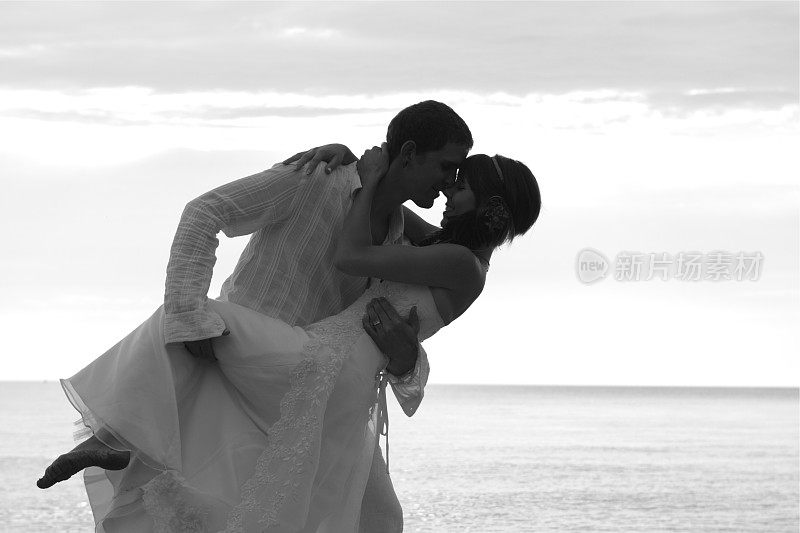 新郎和新娘在沙滩上接吻