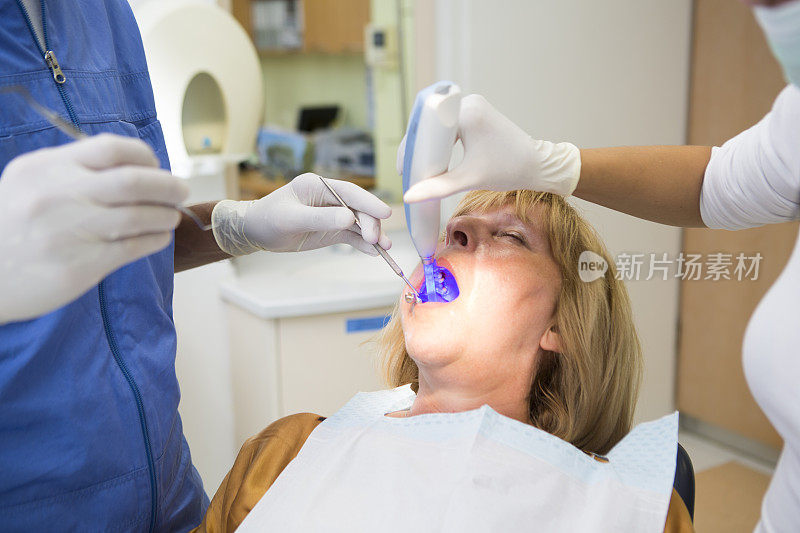看牙医的中年妇女……医生和护士工作