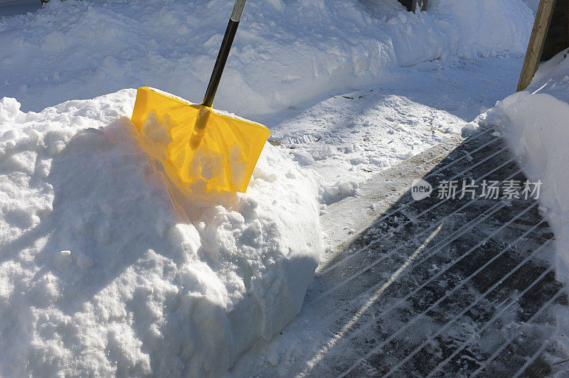 清理干净的人行道附近的雪铲。