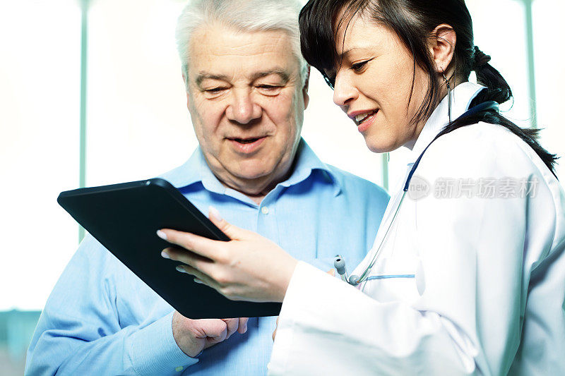 女医生在平板电脑上展示病人的检查结果
