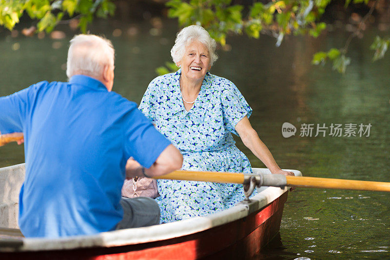 一对快乐的老夫妇在湖上划船