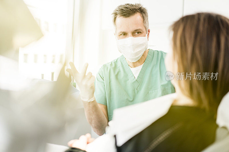 牙科医生戴着口罩在诊所看病人