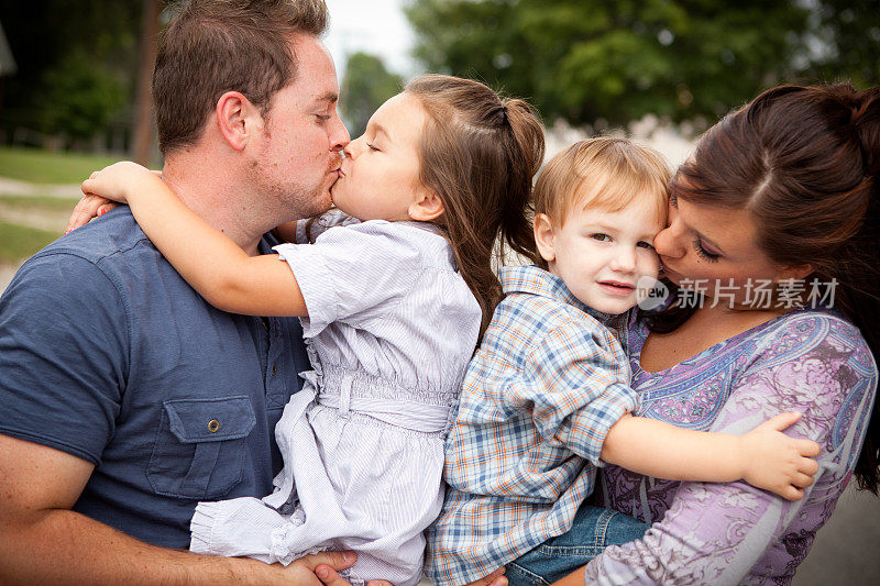 快乐的小家庭在外面互相亲吻